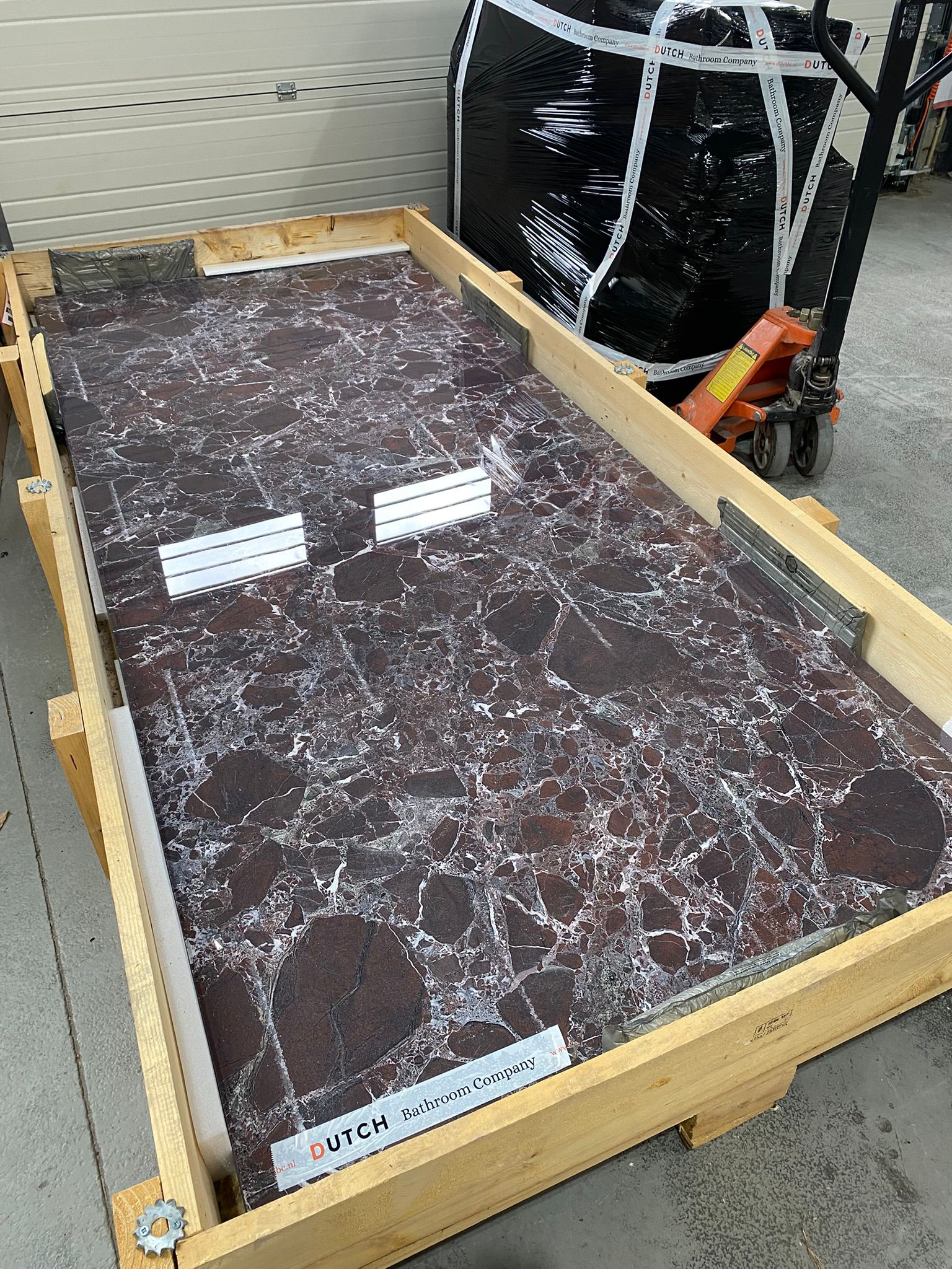 Modern staircase with wooden steps and black railing, decorated with hanging gold lights. Bright white walls feature abstract art, creating a sleek, airy ambiance.