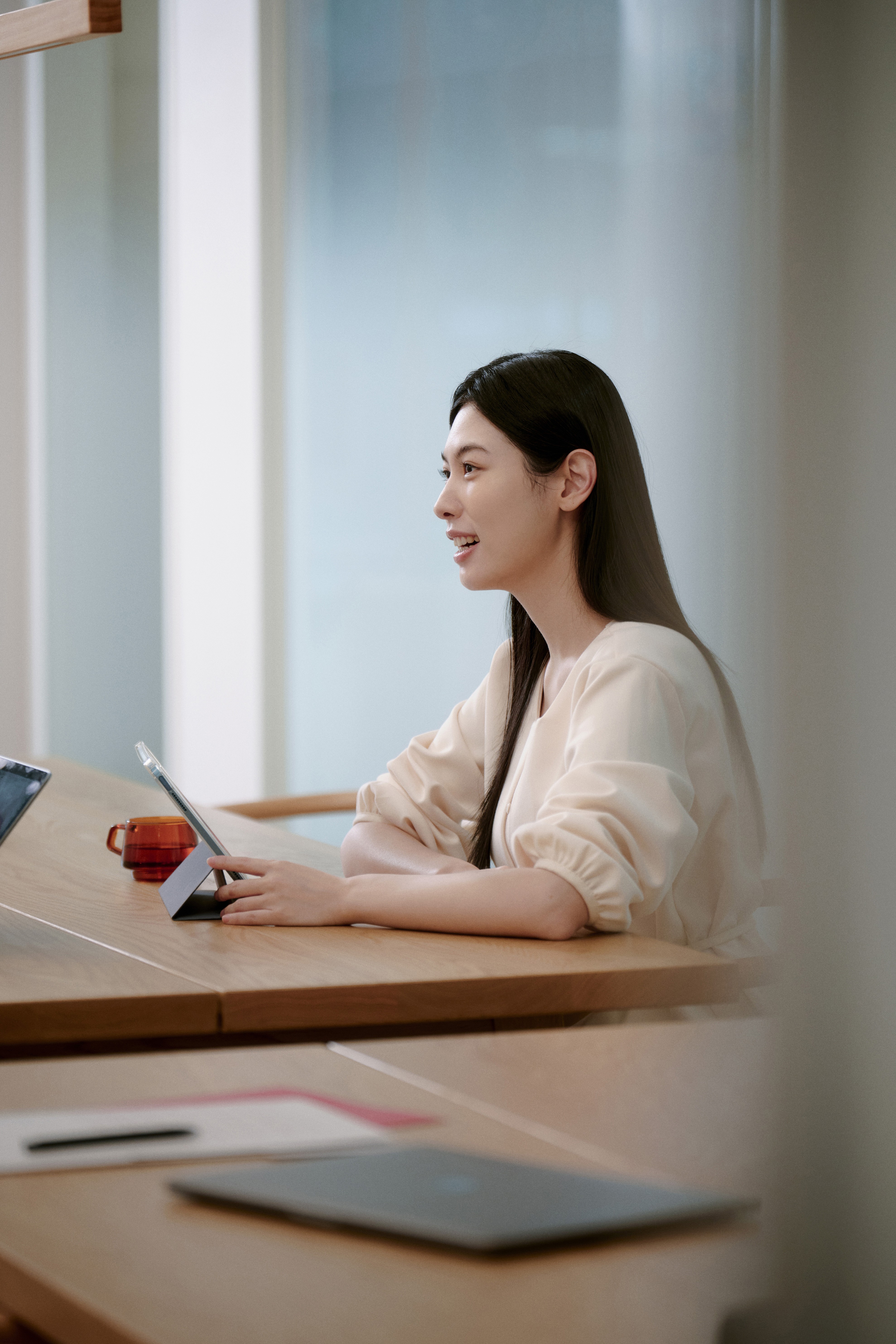 A student deeply focused while studying with a tablet and laptop at 612 Academy, representing precise and goal-oriented language training.