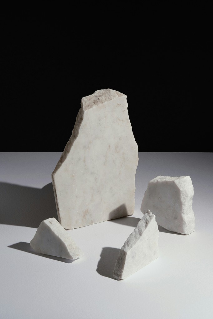 Several pieces of white marble on a white surface.
