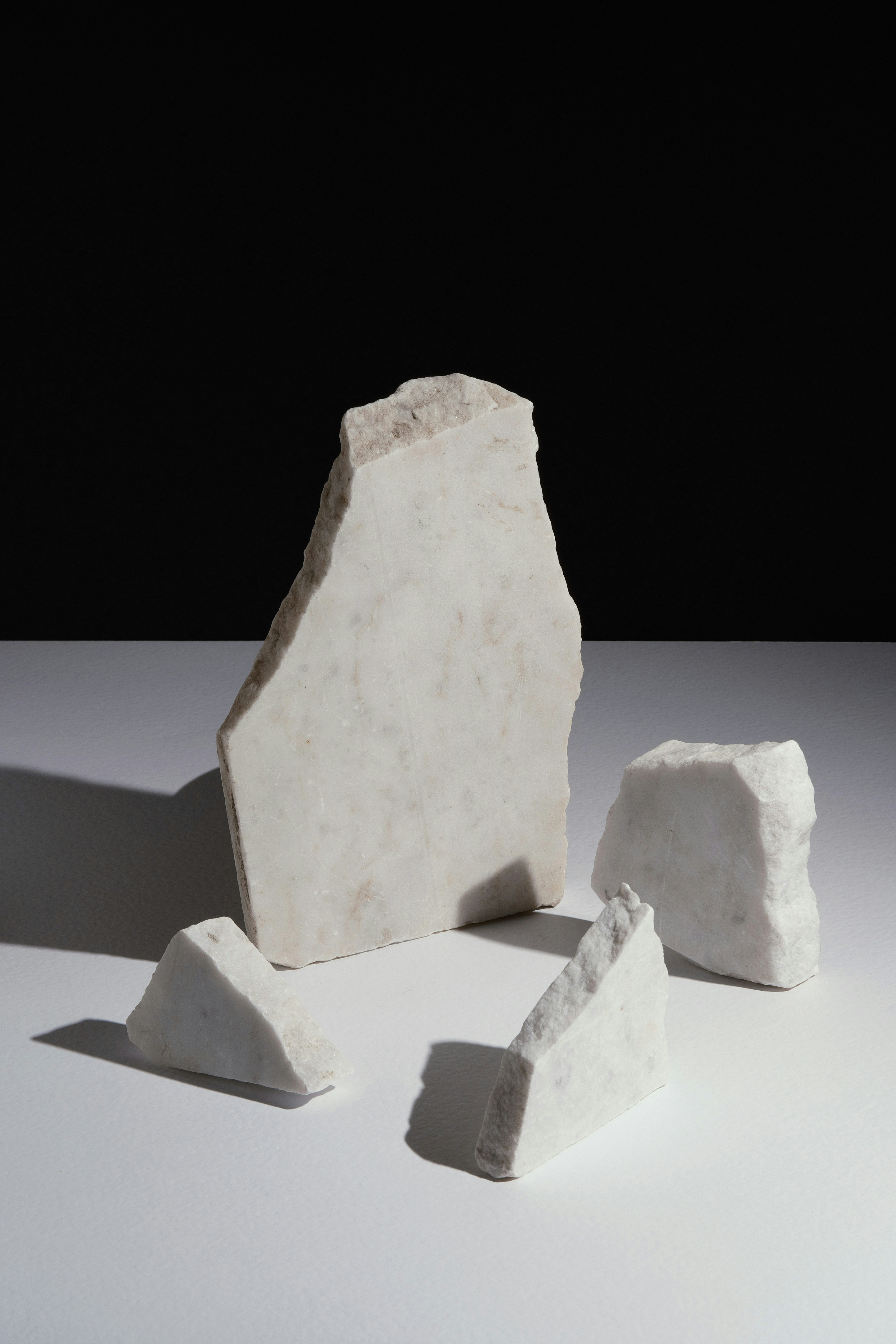 Several pieces of white marble on a white surface.