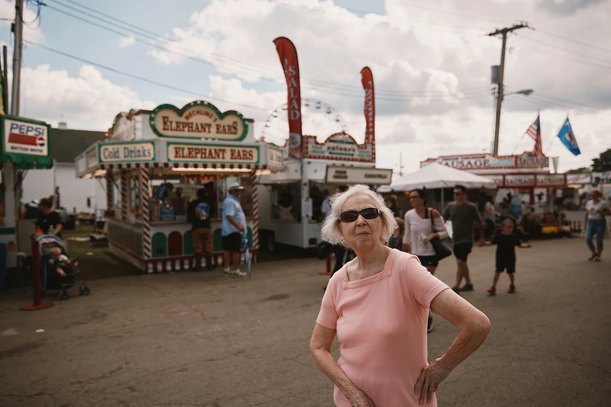 woman standing firm among fair stalls — portrait photography by Tom Kubik