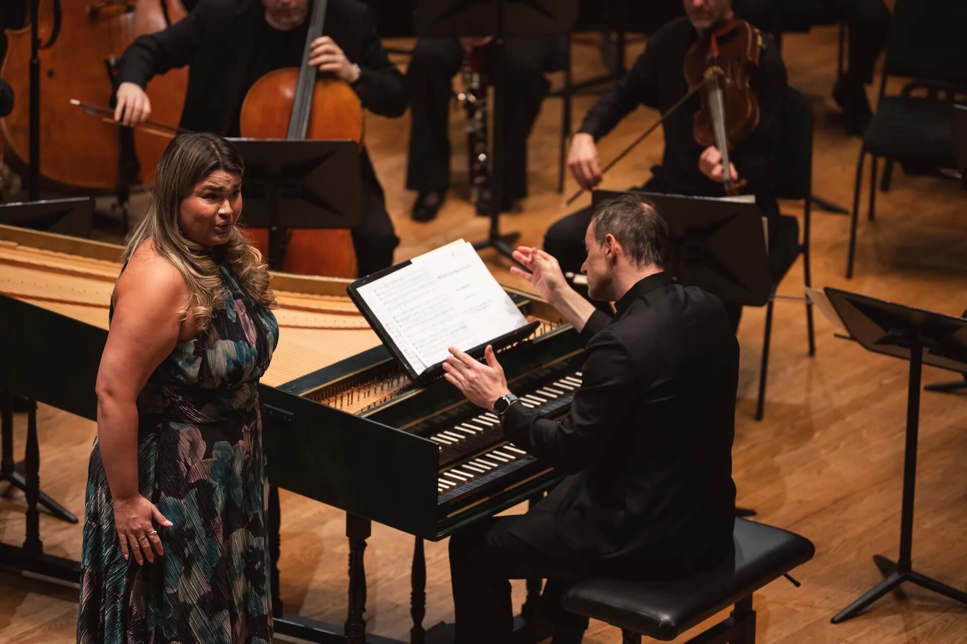 Elisabeth St-Gelais chante accompagnée d’un claveciniste lors d’un concert de musique classique avec un ensemble instrumental en arrière-plan.