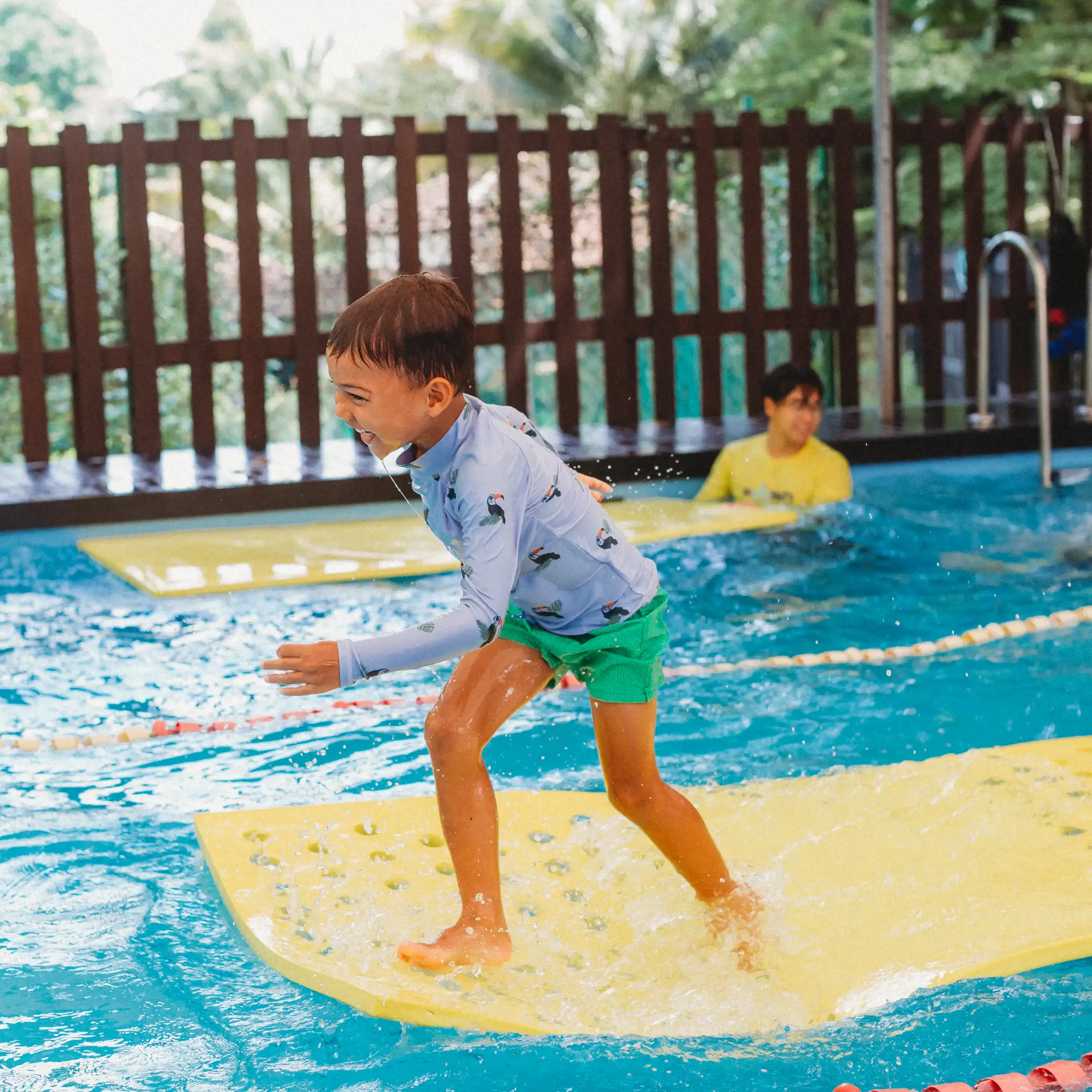 Boy crossing a floating mat during a Swish holiday swim camp challenge