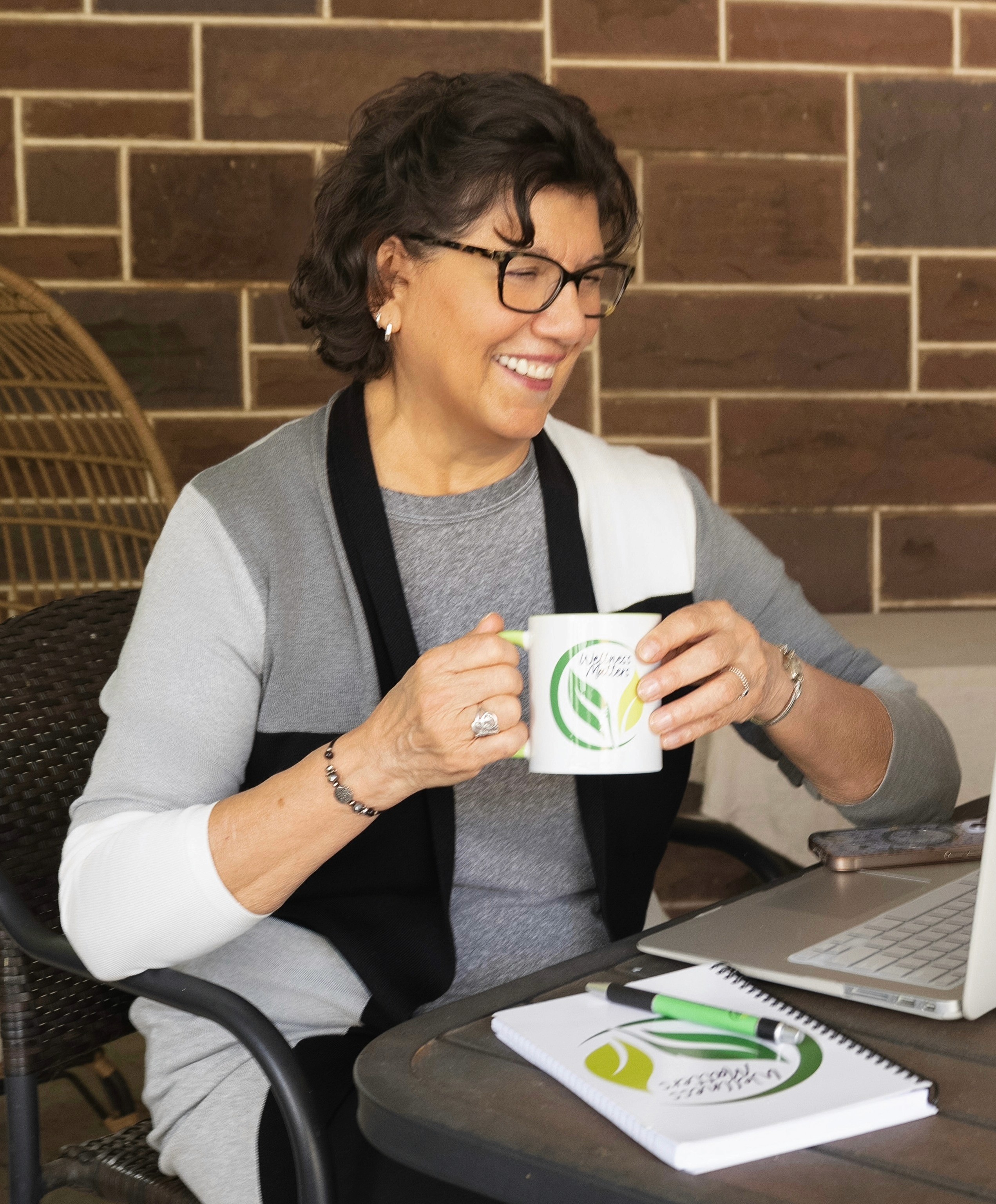 Carol Bruce, founder of Wellness Matters, smiling in her office with coaching certifications in the background.