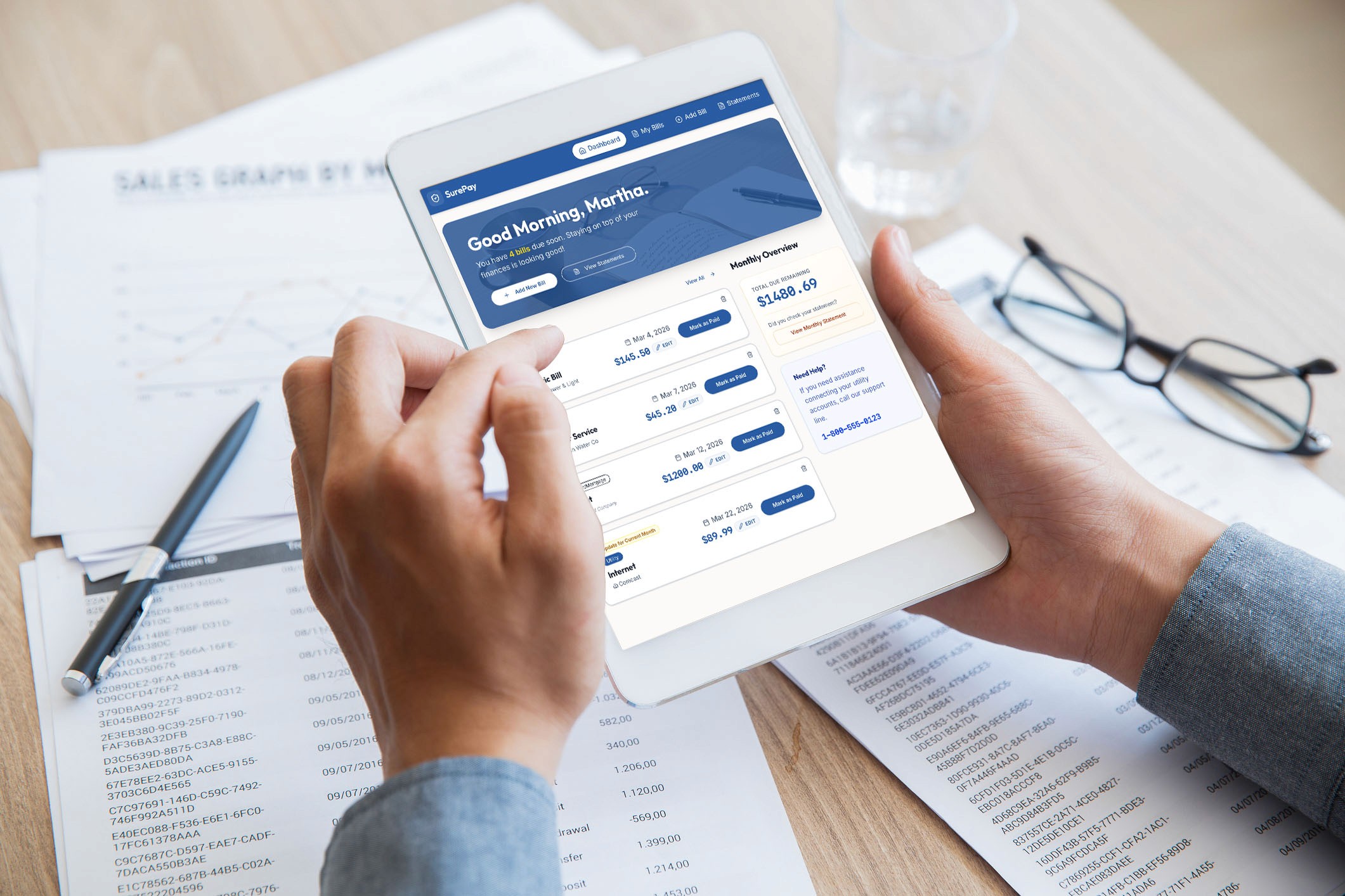 Senior citizen using Surepay on a white tablet at a desk.