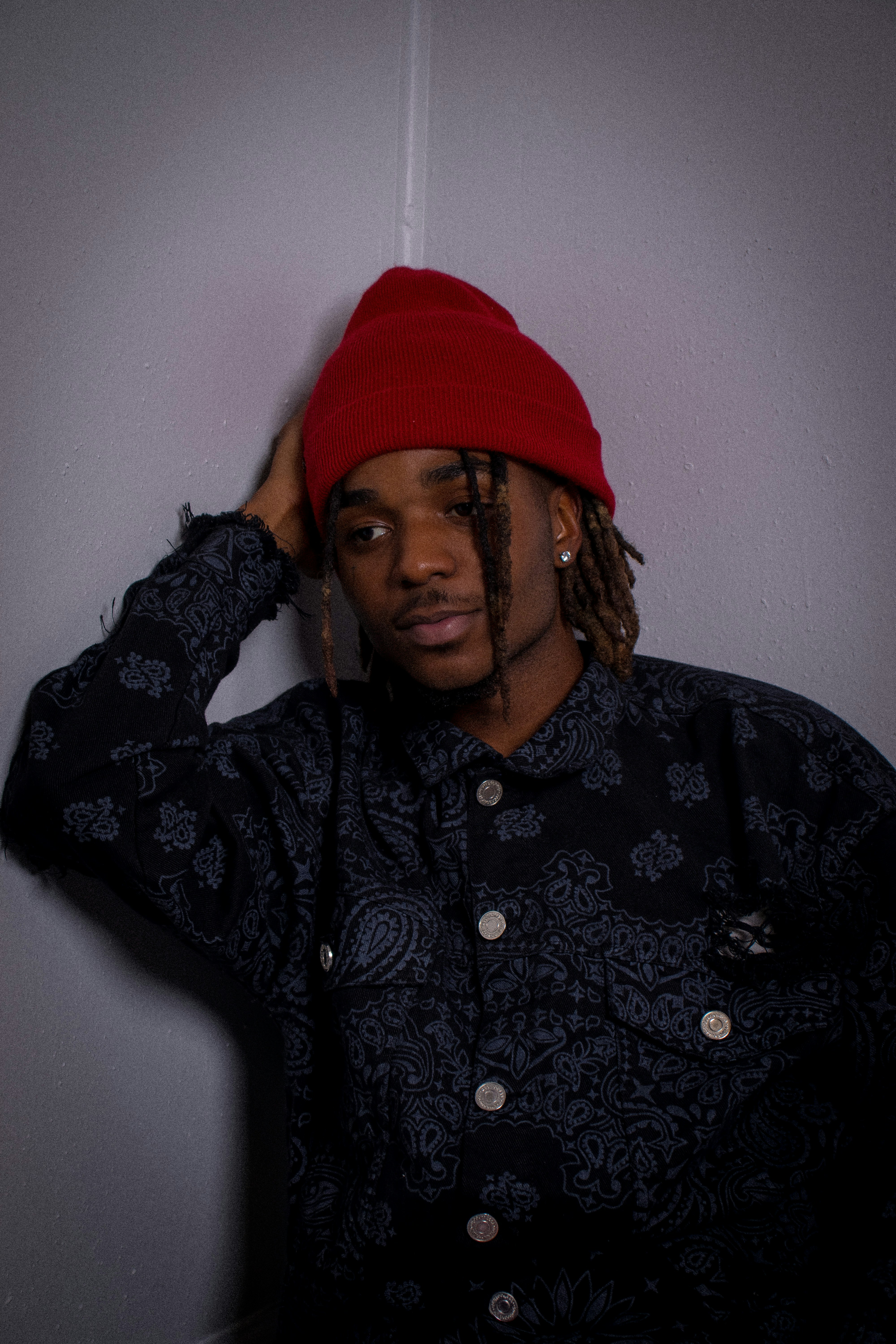 a man with dreadlocks wearing a red hat