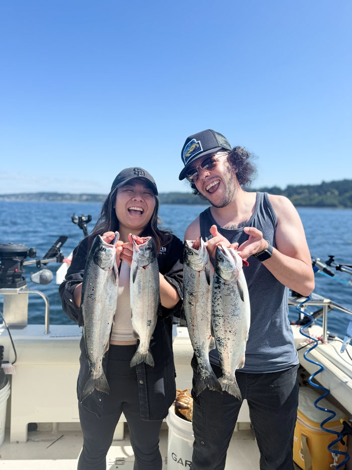 friends catching salmon at a seattle fishing charter boat