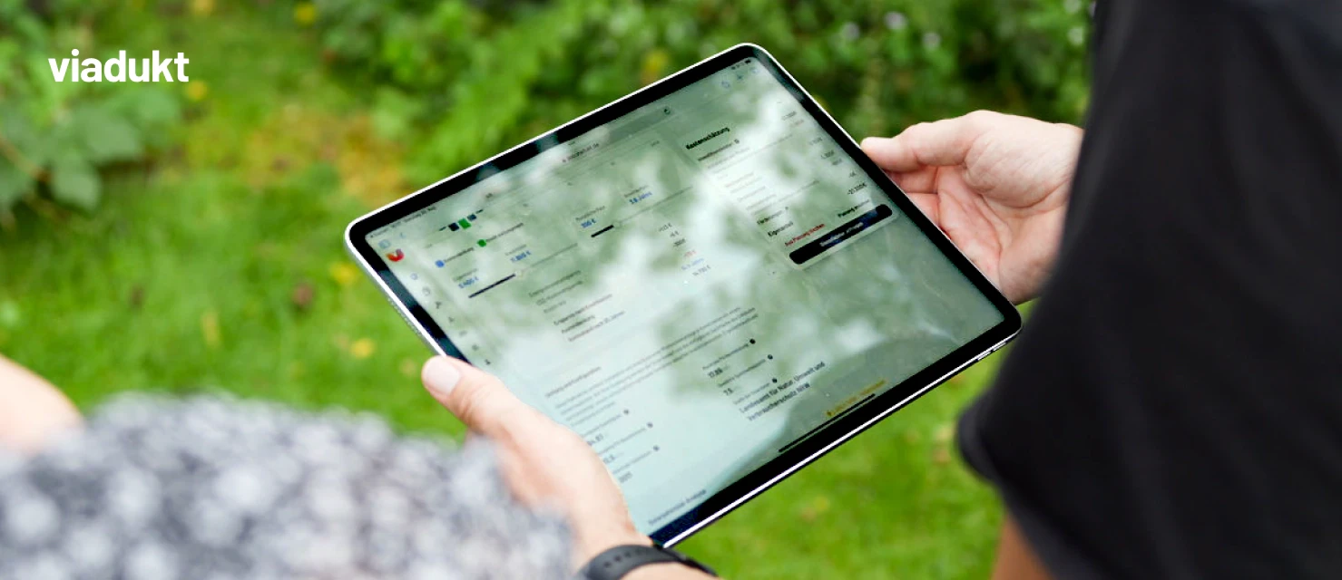 Handwerker Fersing hält ein Tablet in der Hand um auf der Plattform viadukt Gebäudedaten aus der Analyse einzusehen um seine Kundin zu beraten