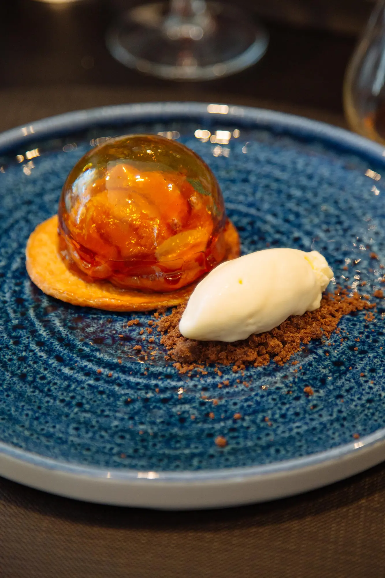 Dessert gourmet del Ristorante Unico a Cantù con gelato artigianale, crumble croccante e sfera di caramello.