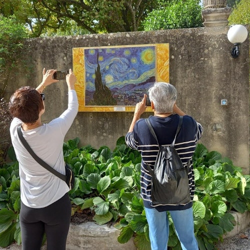 Dva lidé zobrazení zezadu si fotografují plaketu s malbou od Vincenta van Gogha