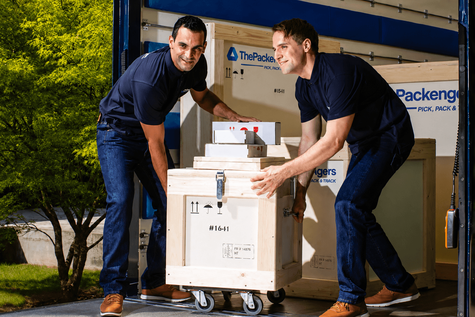 Professional art handlers loading specialized wooden crates and parcels marked with fragile handling icons, showcasing ThePackengers' secure transport and packaging solutions.