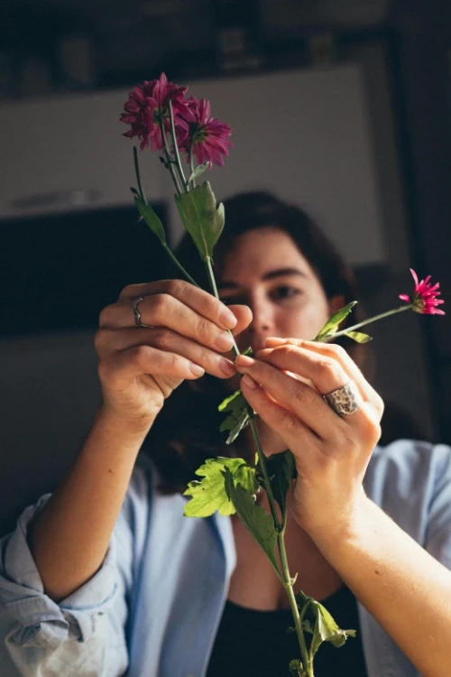 Florist separating a leaf from the stem of a flower