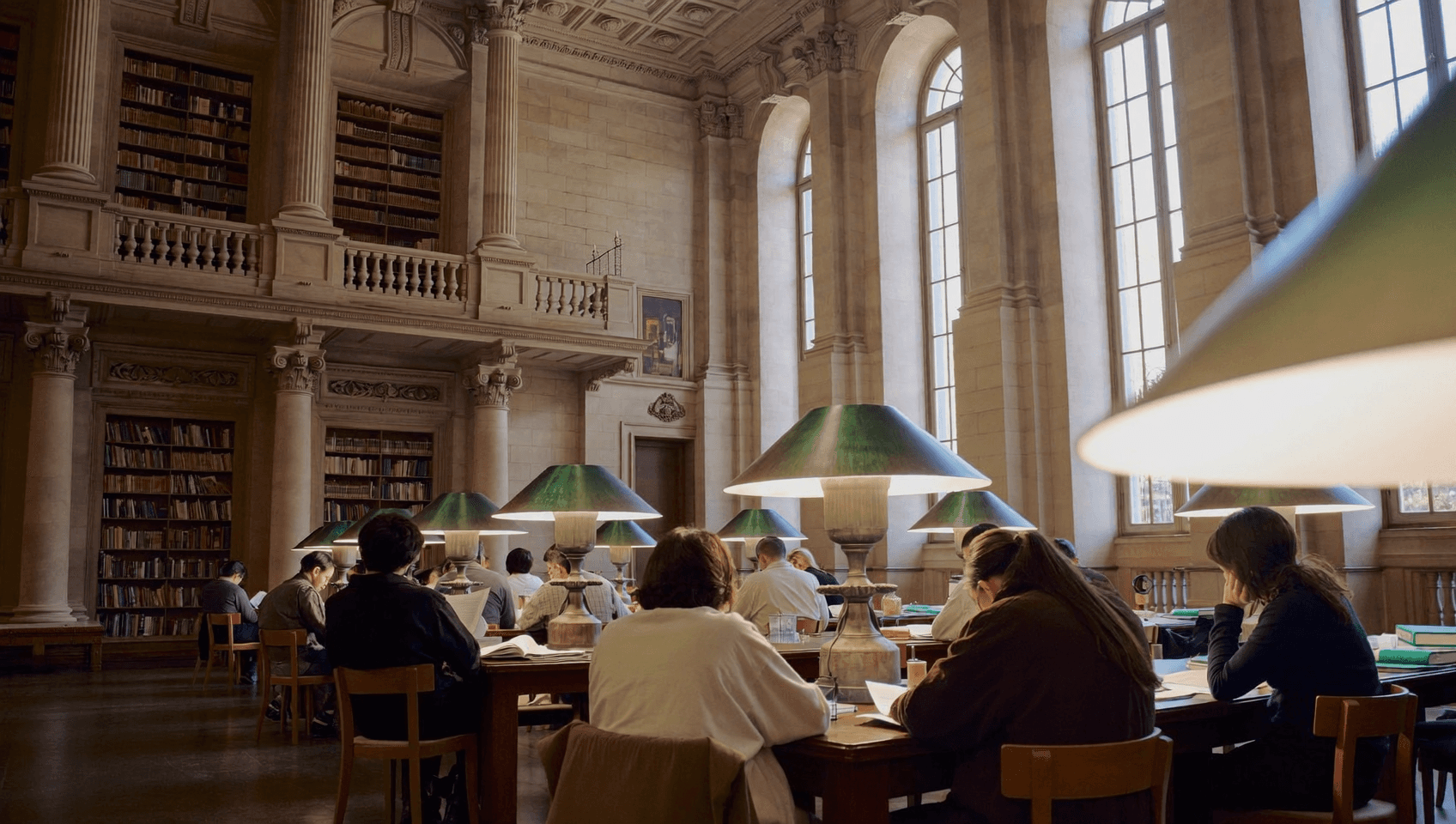 Sunlight streams through trees onto a historic building.