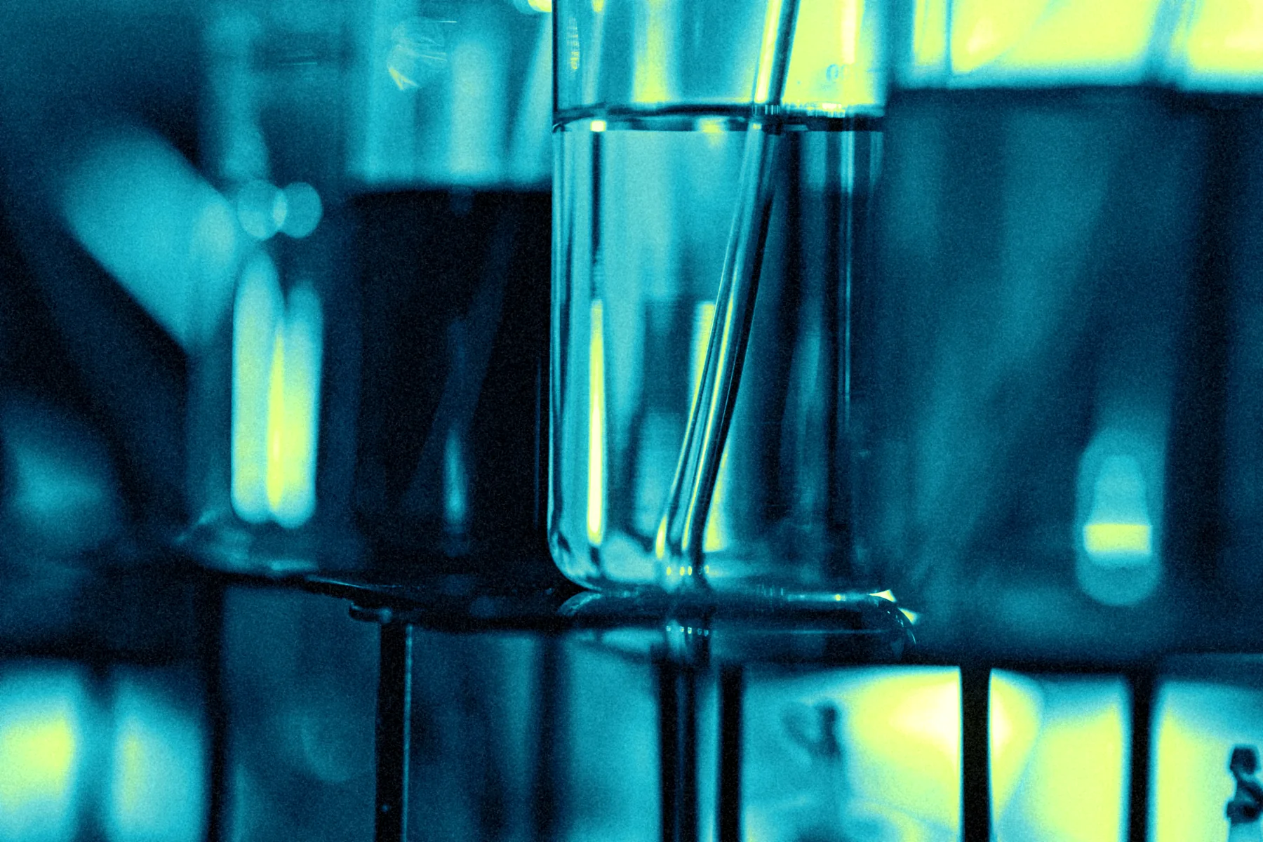 Laboratory beakers glowing lime and cyan