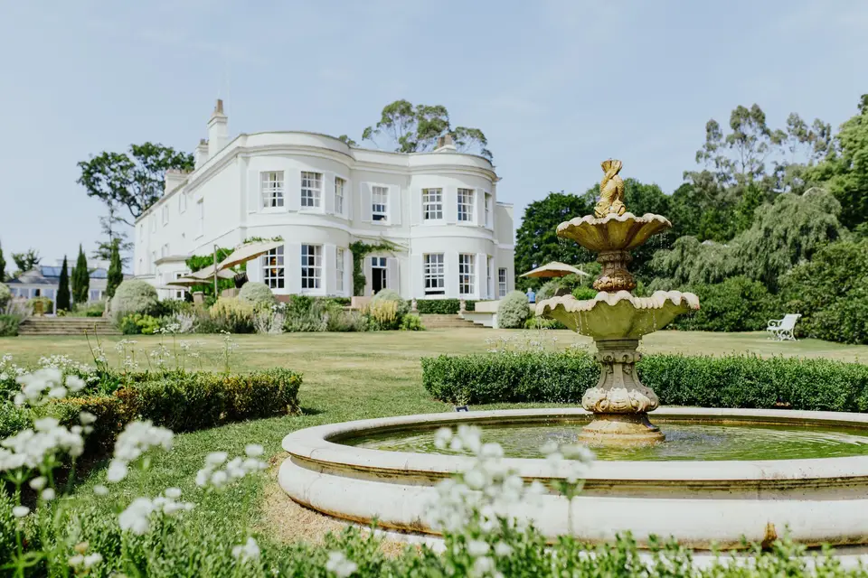 Deer Park Country House and landscaped gardens with a stone fountain in Devon