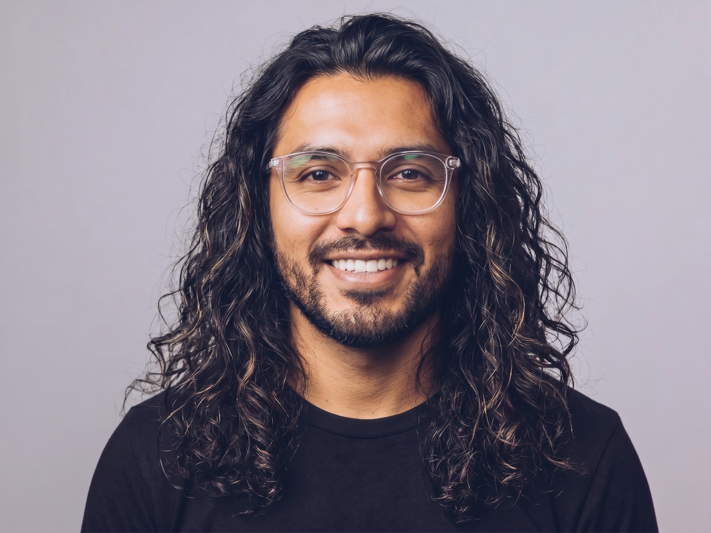 A person with long hair wearing glasses and a beard.