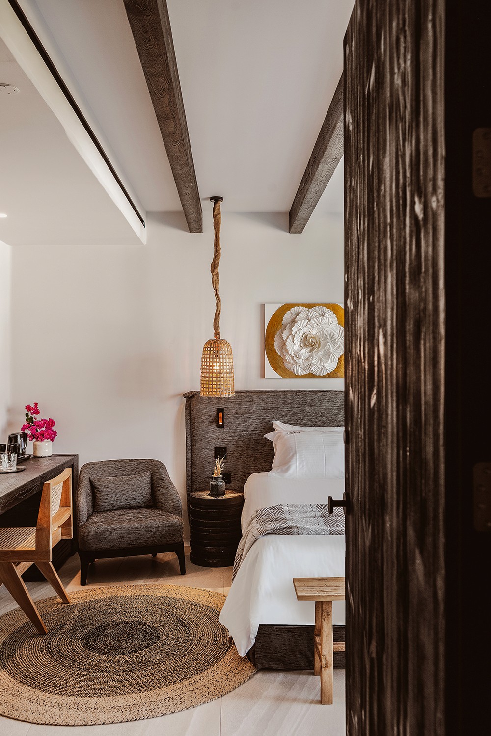 High-contrast Mykonian junior suite in Ayia Napa with organic white-wash walls and bespoke timber headboard by topos design studio