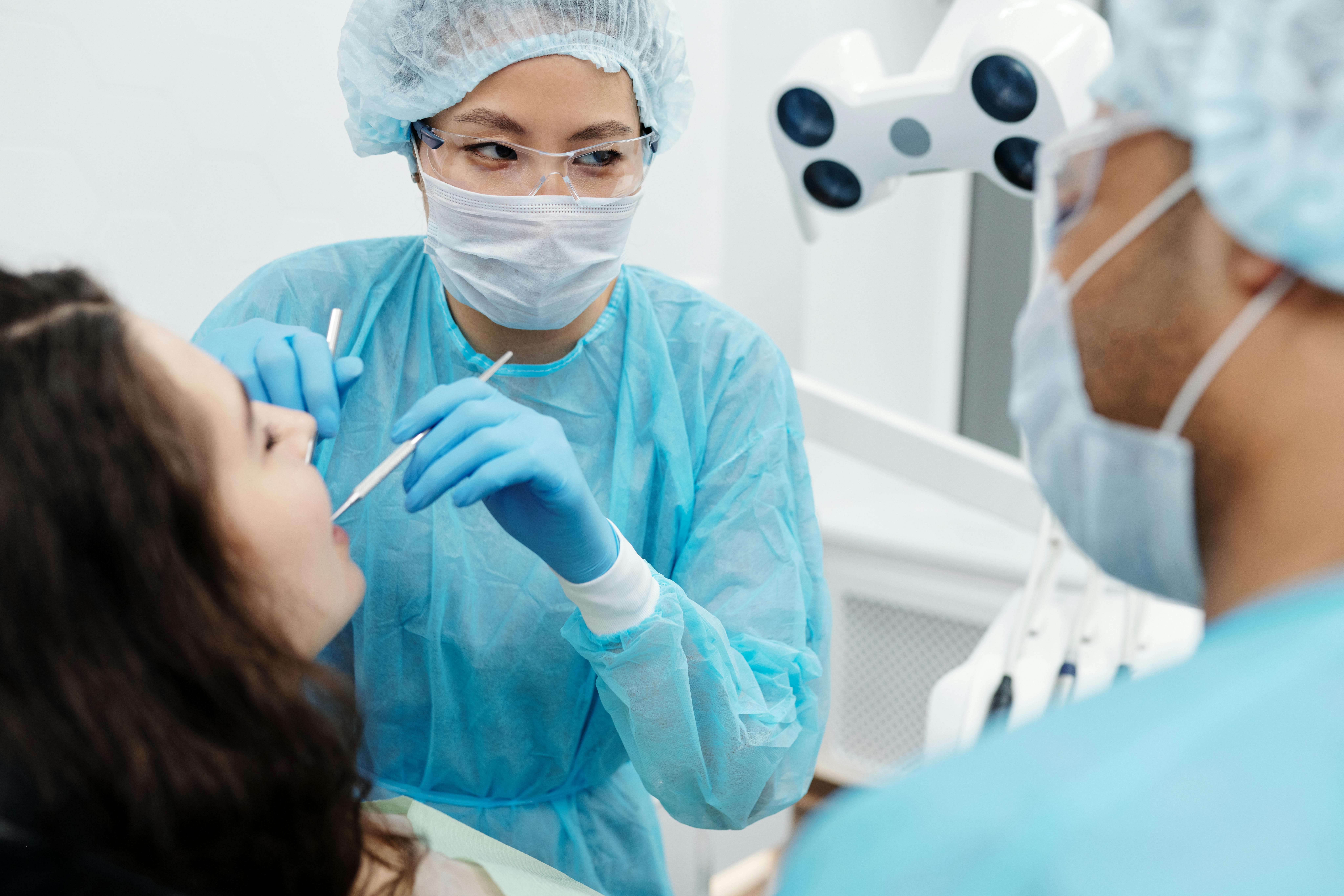 Two dental hygienists working on a patient