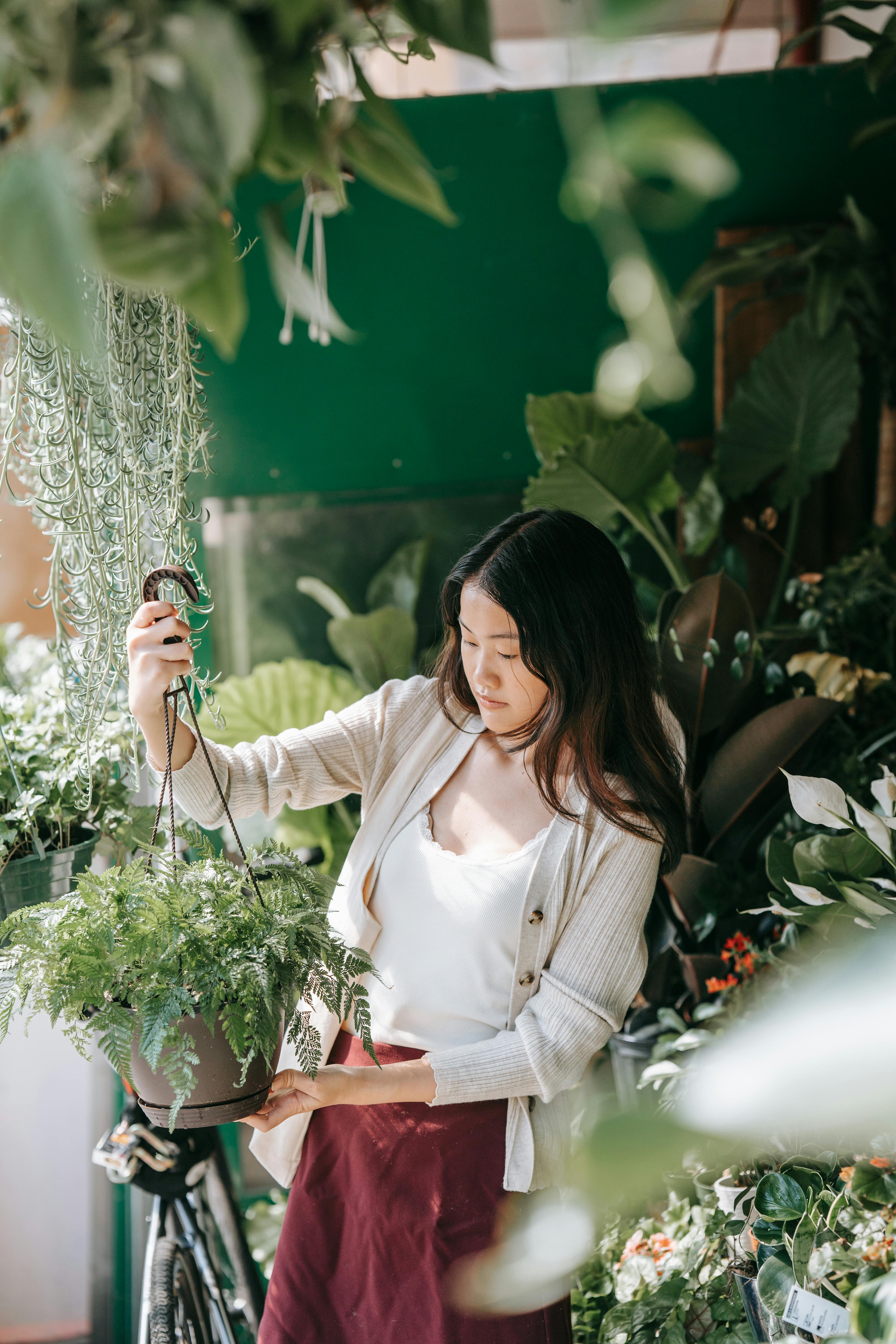 a-woman-examines-hanging-plants-in-a-lush-green-indoor-plant-store. - sasha-kim (pexels)