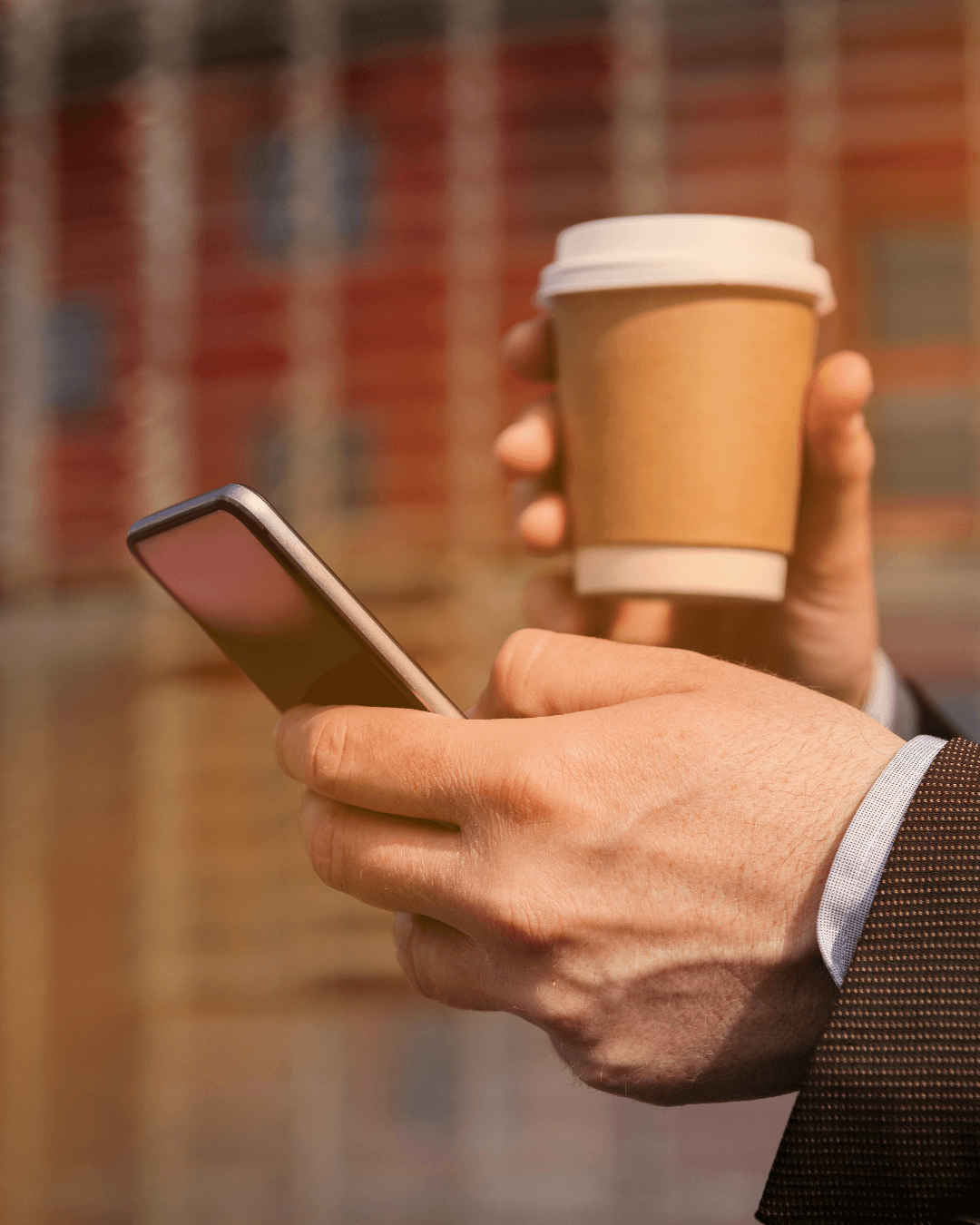 close van handen met een telefoon en koffie in de handen