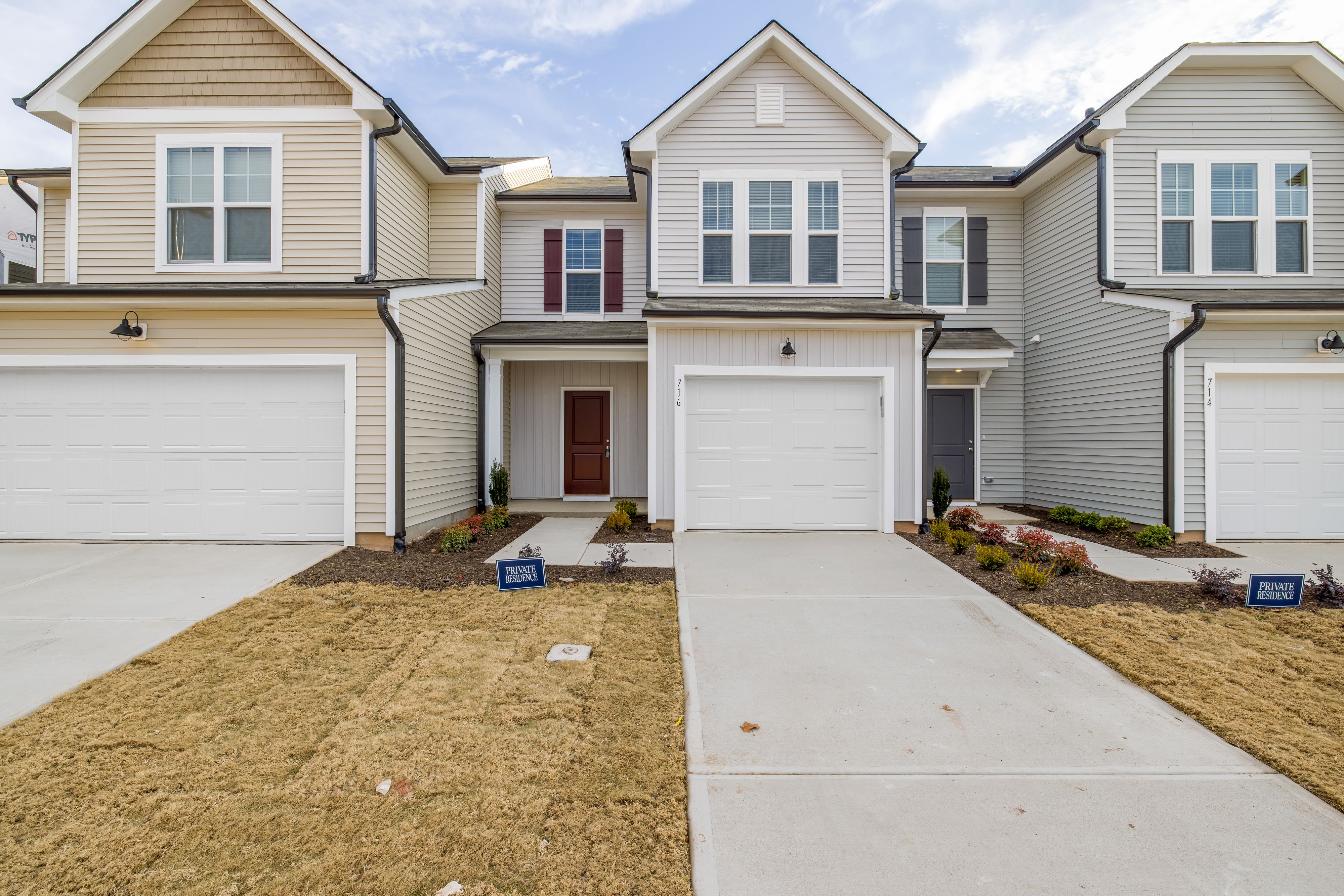 Residential townhomes with attached garages and entry doors representing Texas Residential Code fire door requirements for garage openings