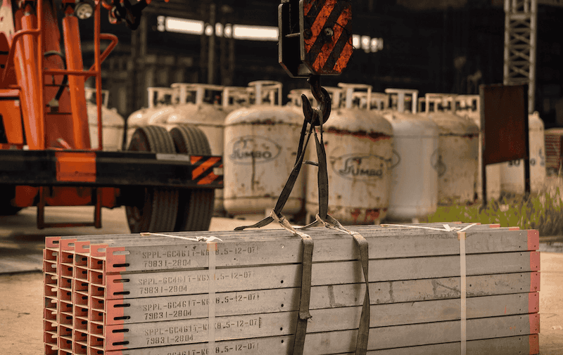 Truck with mounted crane performing a heavy lift rigging operation.