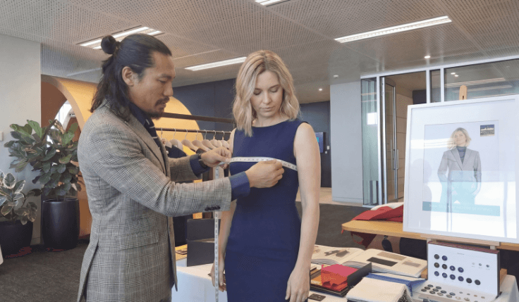 Custom tailor taking measurements for a women’s masculine suit fitting and personalised silhouette