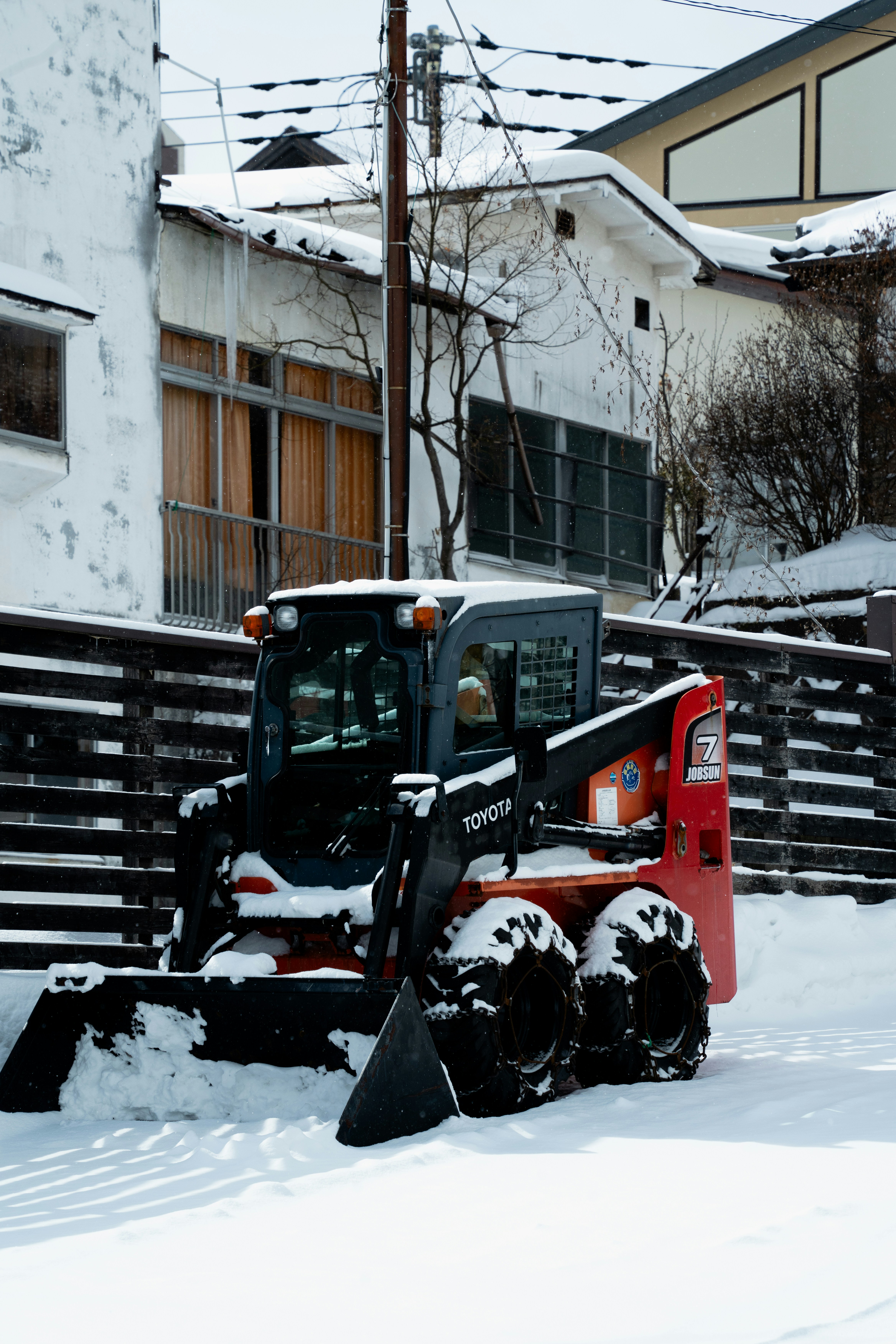 Snowplow clears a street in a snowy town.