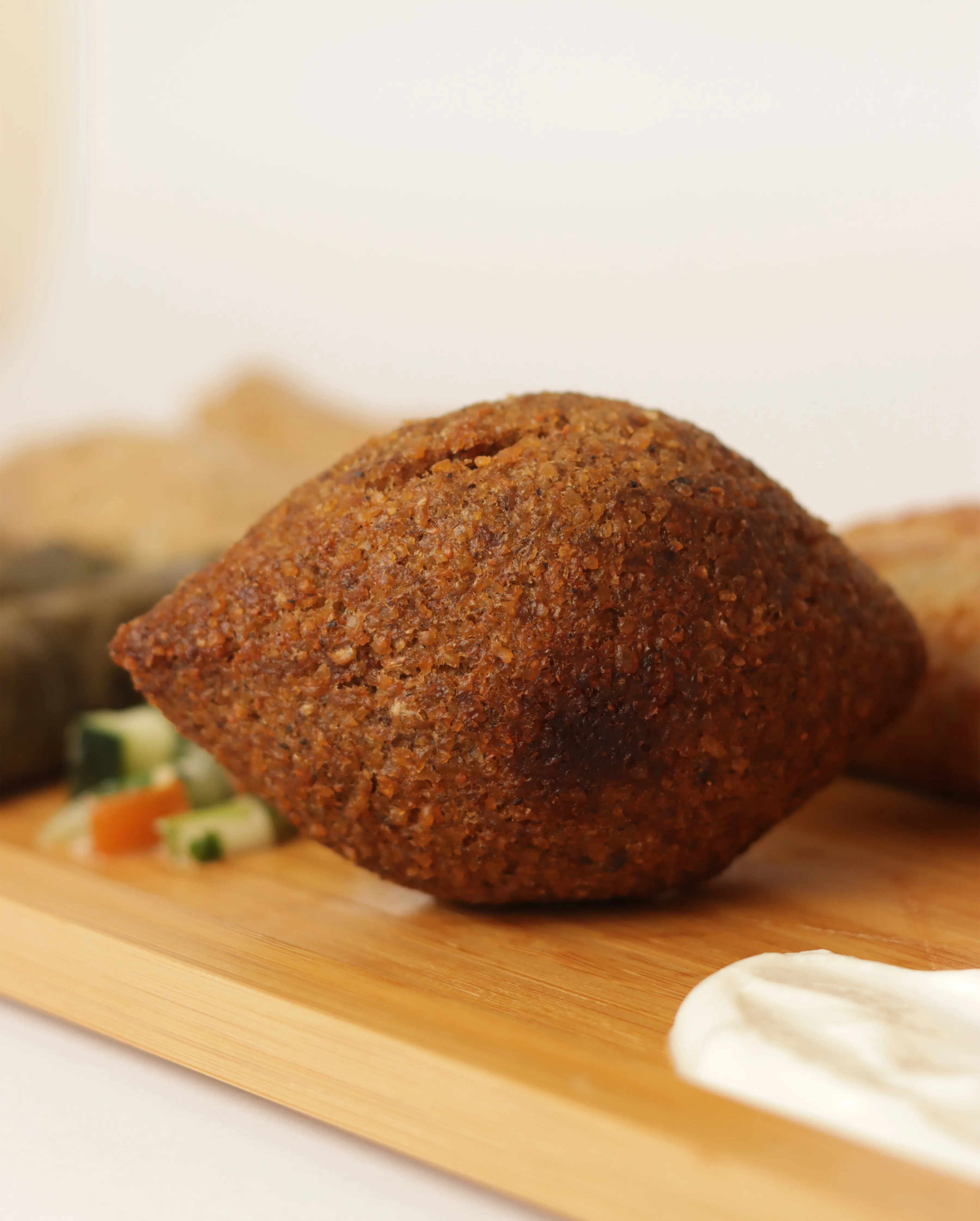 Kibbeh libanés sobre tabla de madera.