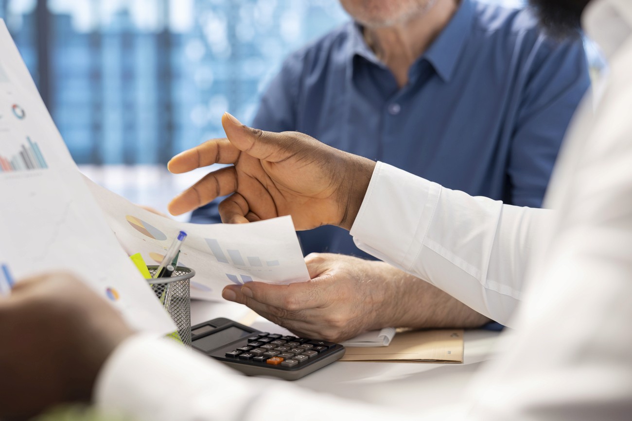 Bandeira do Brasil com notas de real e uma caneta sobrepostas, simbolizando a economia nacional e os princípios da Lei de Liberdade Econômica