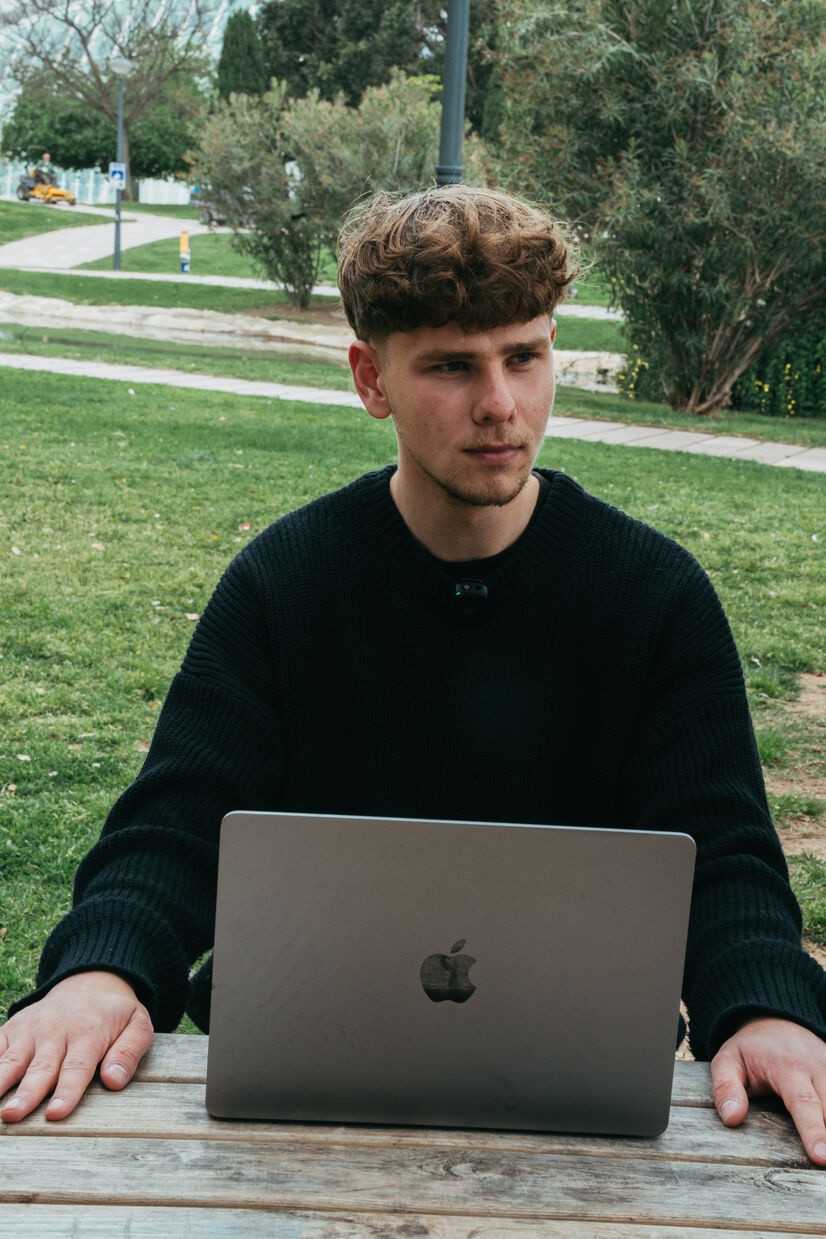 Student zit acher laptop en kijkt pijnzend in de verte