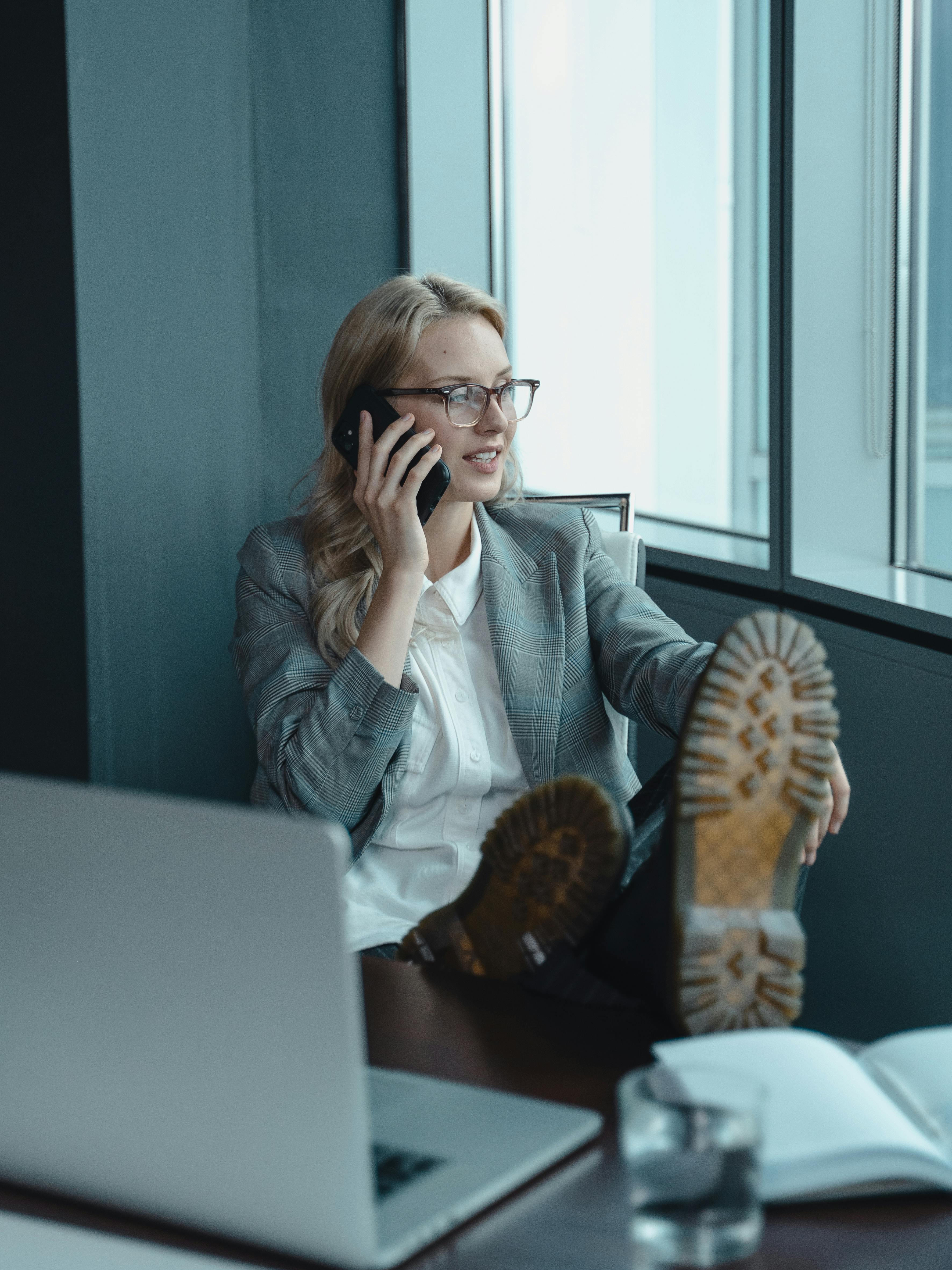 professional-woman-in-office-attire-making-a-phone-call,-feet-up-on-desk-creatin - tima-miroshnichenko (pexels)