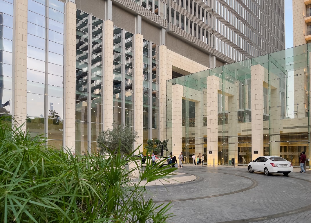 Ground level entrance and drop-off area of a luxury mixed-use building for real estate clients.