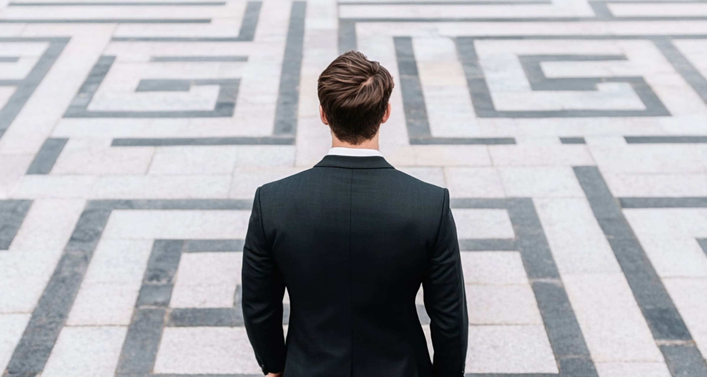 Man facing a maze, symbolizing uncertainty.