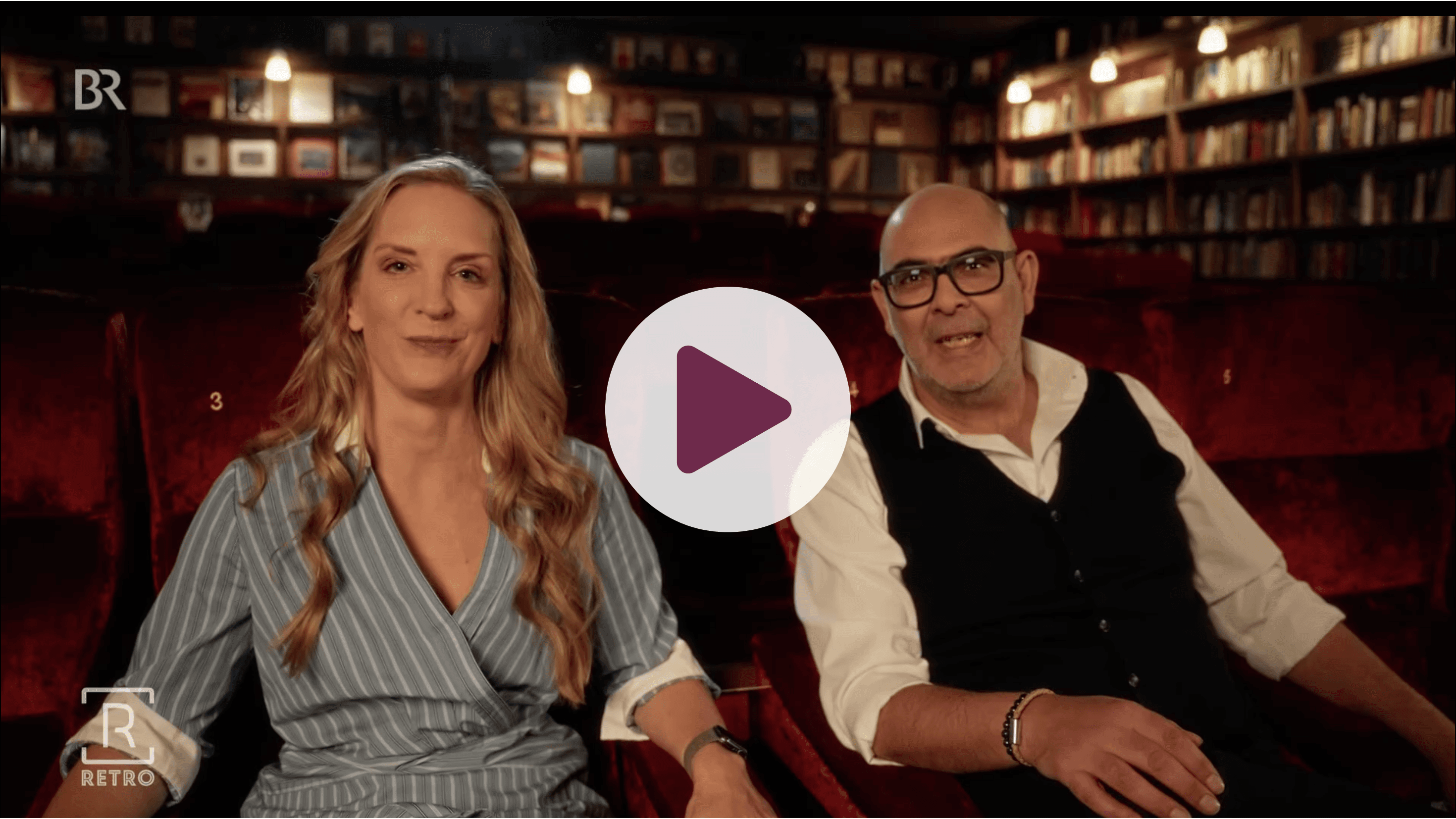 Daniel Fürg (links) und Caro Matzko (rechts) sitzen gegenüber und unterhalten sich. Im Hintergrund ein Bücherregal und eine Pflanze