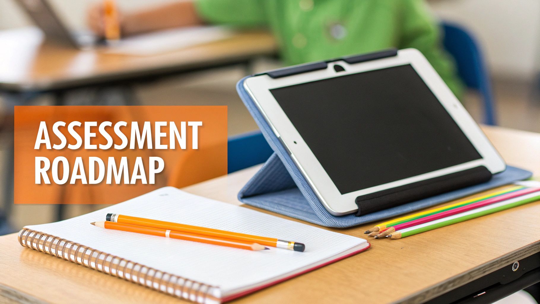 A classroom desk with a tablet, notebook, and pencils, displaying 'ASSESSMENT ROADMAP'.