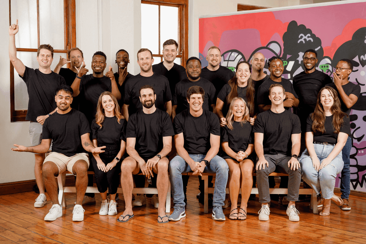 Team photograph of the Cue staff, a mix of men and women smiling at the camera.
