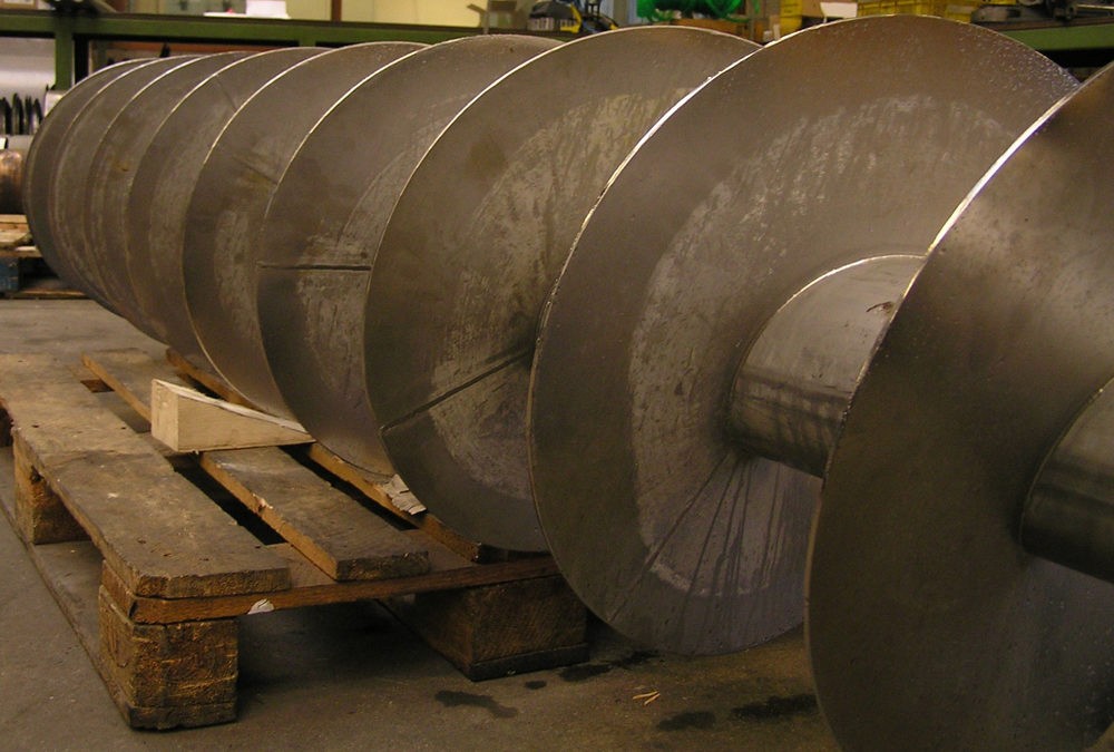 Grote metalen schroefas op pallets in industriële werkplaats van Plasma Service