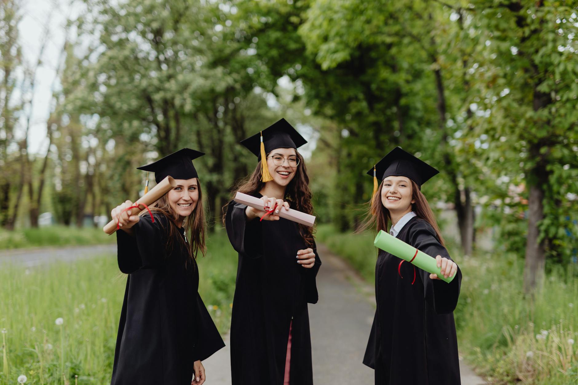 A group of graduates in blue caps and gowns tossing their tassels during a high school graduation ceremony.