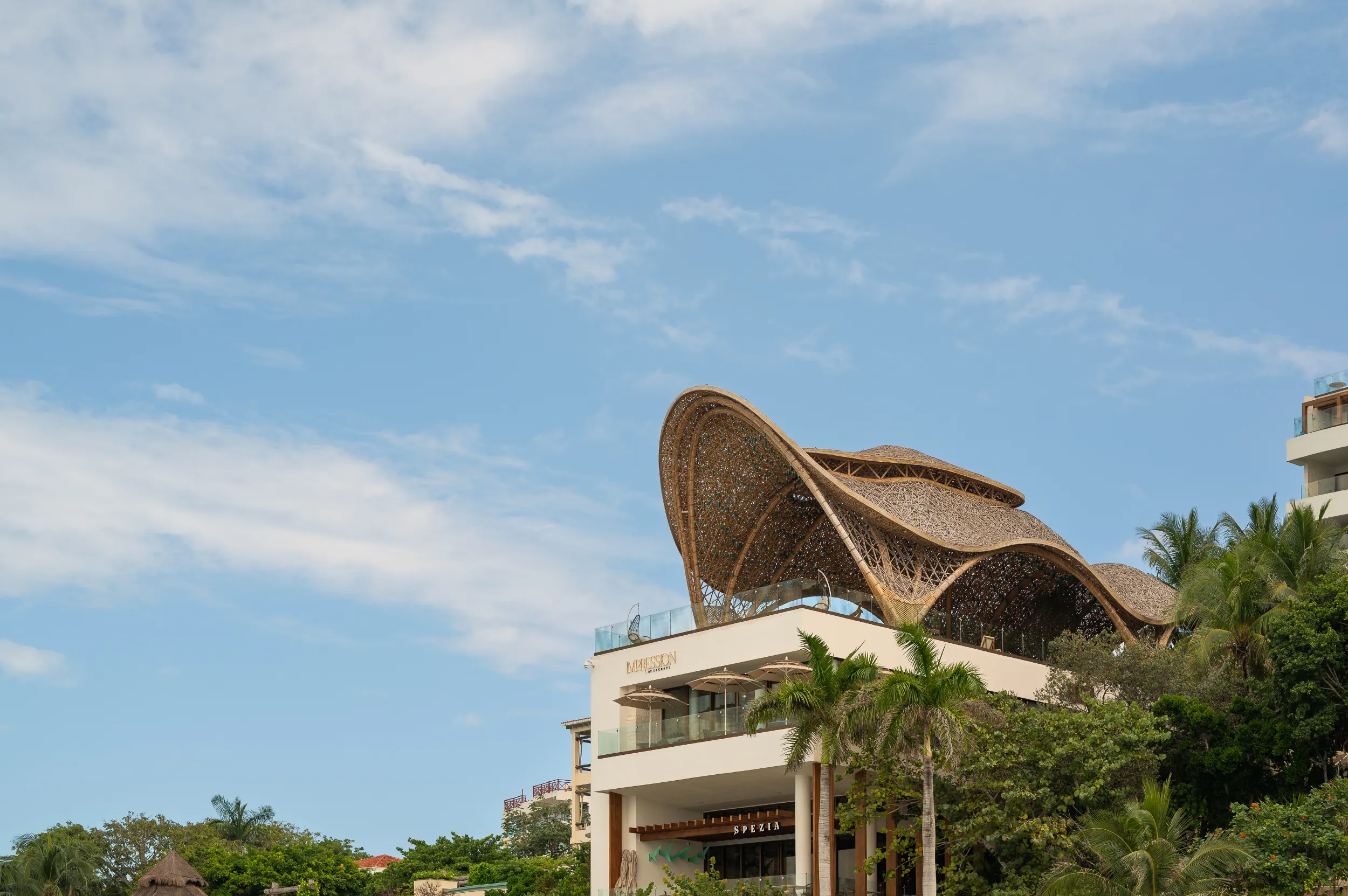 Monumental sustainable bamboo structure at Hyatt Impression Isla Mujeres, showing the iconic bio-parametric architecture against the blue sky.