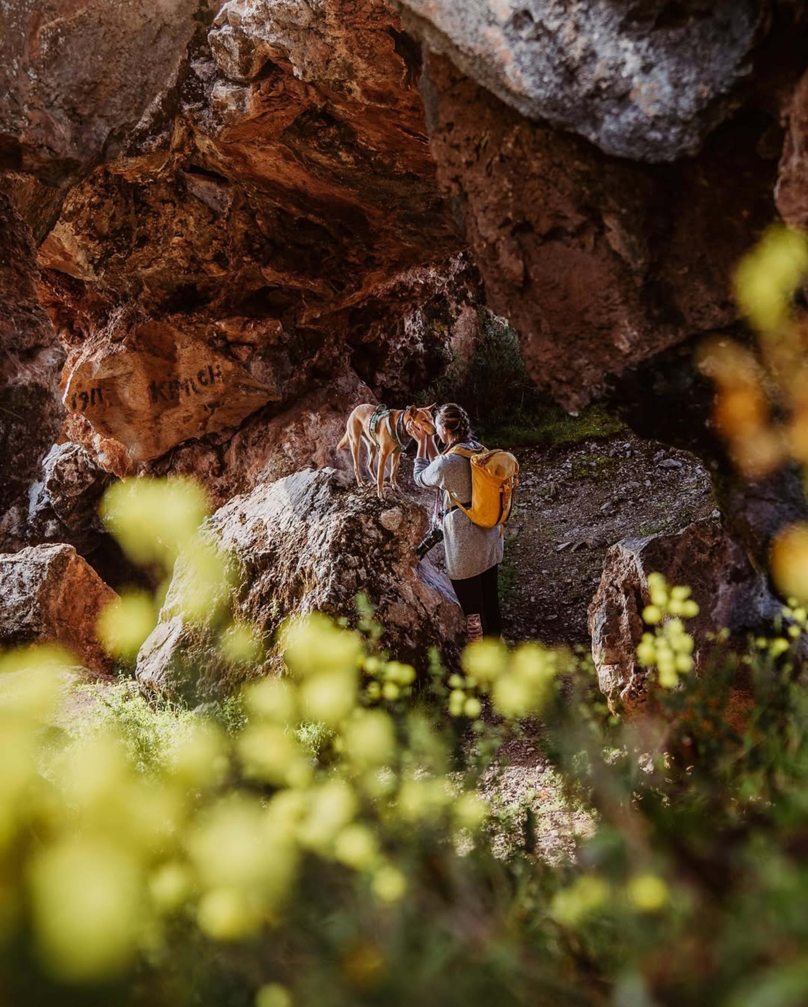 Polarsteps Explorer Steffanie tackles a walk beneath a rocky overhang with her dog Olive