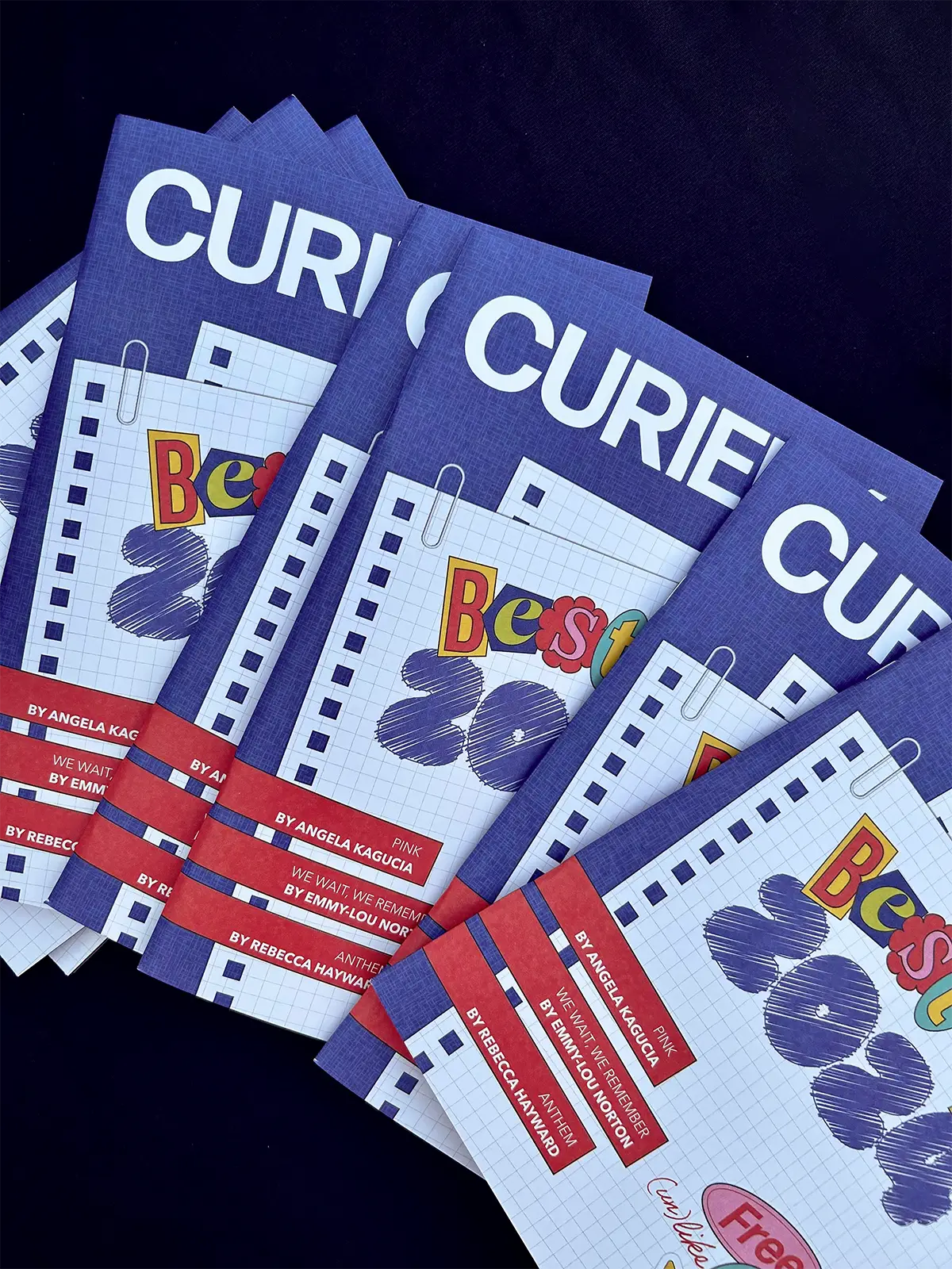 A stack of Curieux Best of 2024 magazines on a dark navy background