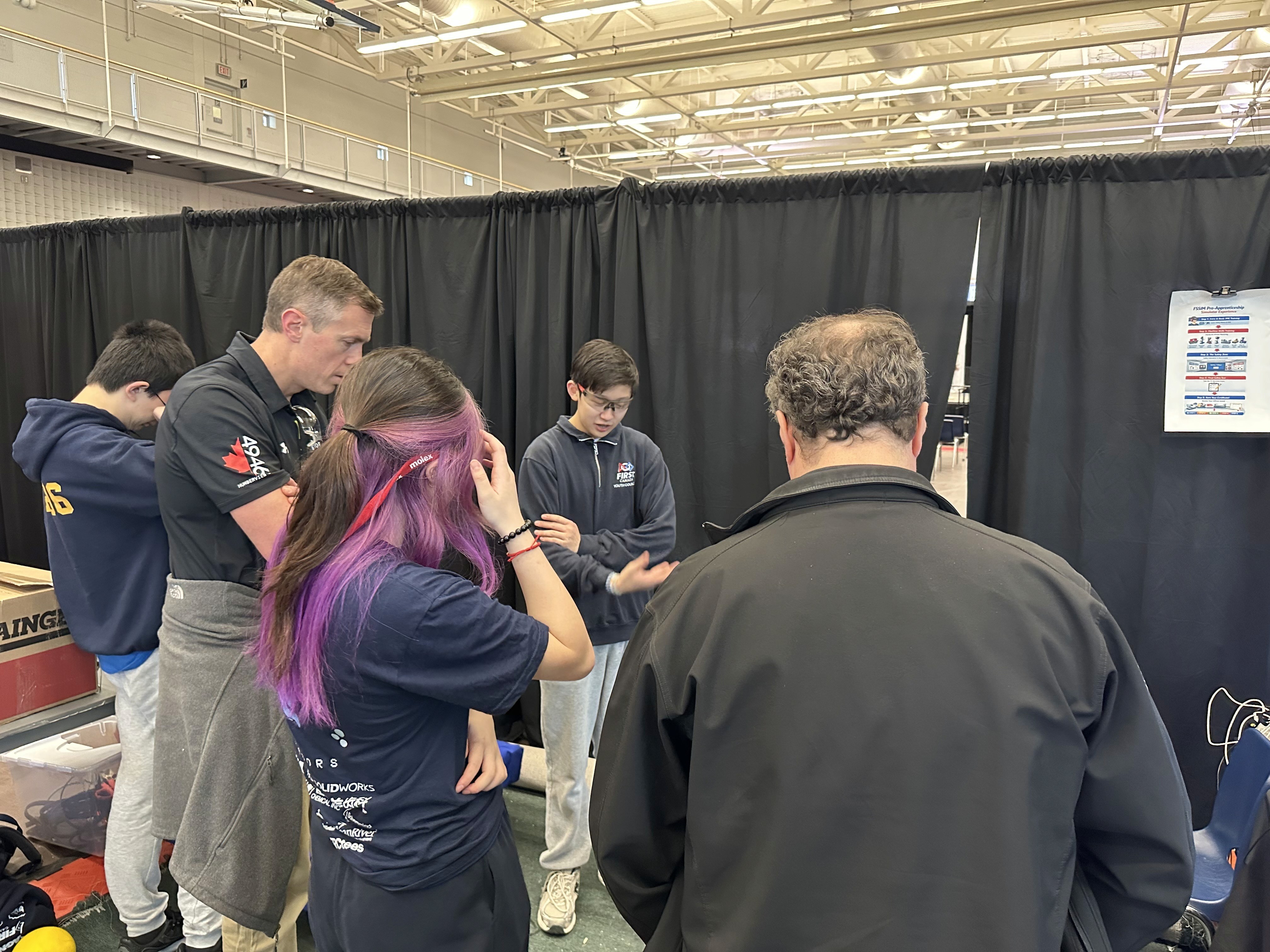 FRC Team 10015 Bubbles Captain Ryan Zhang explains the 2026 season robot, Ballista, to FRC mentors at the FTC Ontario Provincial Championship.
