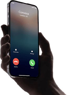 Hand holding a smartphone with a blank screen against a dark background.