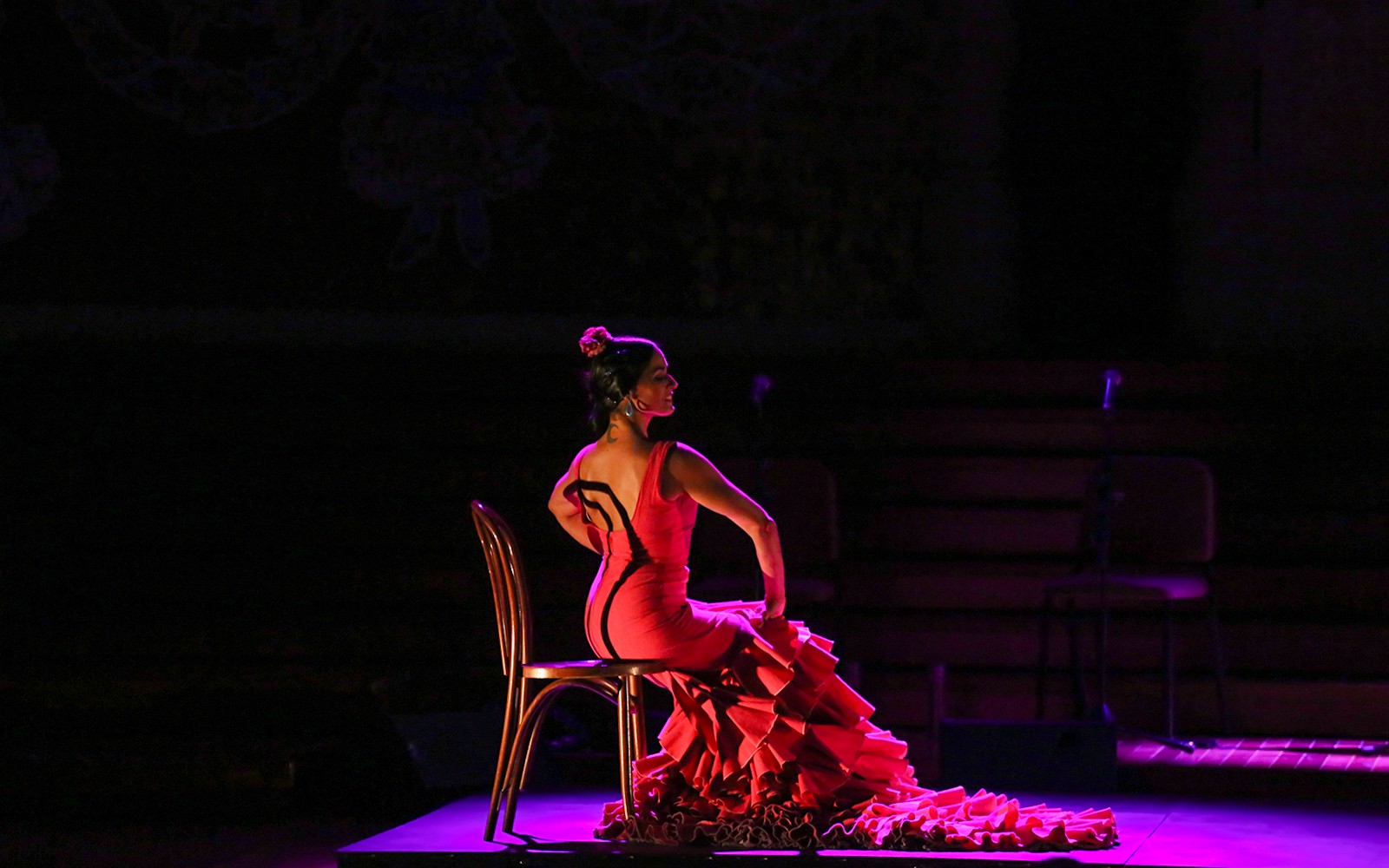 Flamenco dancer in red dress performing at Poliorama Theater's Gran Gala Flamenco Show.