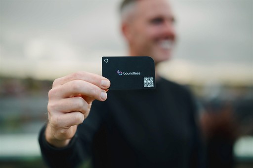 Two men discuss a project while standing at a laptop in an office.
