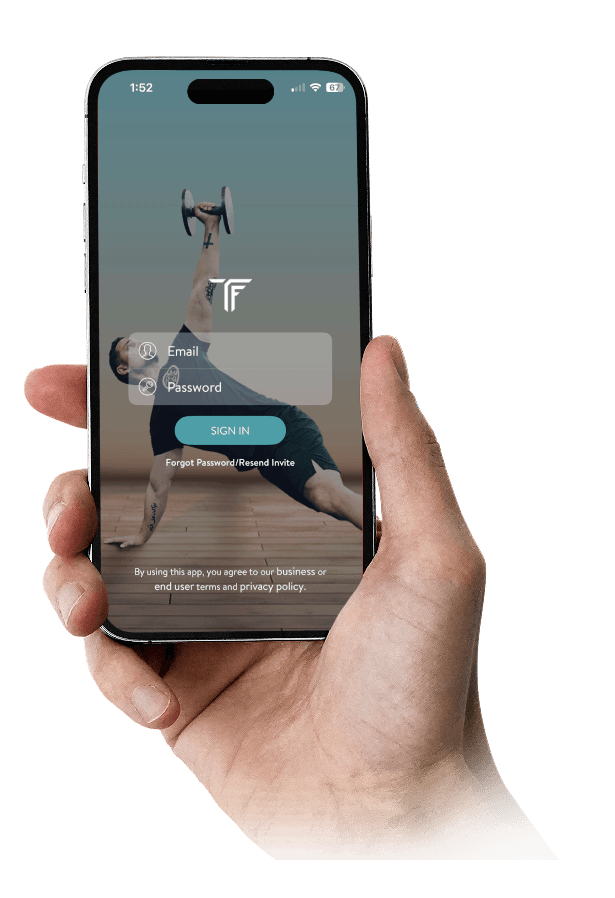 Person holding a phone displaying a fitness app login screen with email, password, and sign-in option.