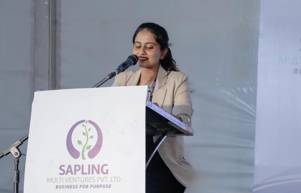 Woman addressing audience from a podium, smiling as she speaks