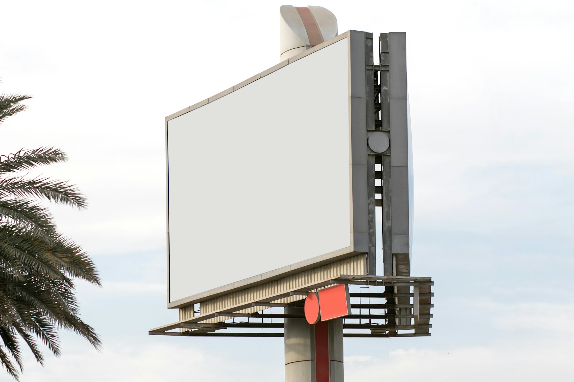 A blank white billboard against a pale sky