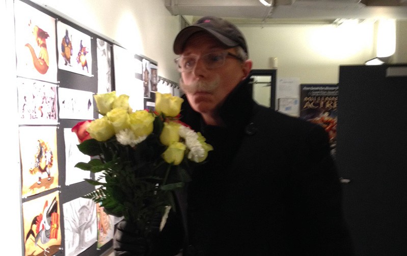 A photo of a teacher receiving flowers from the students in a classroom.